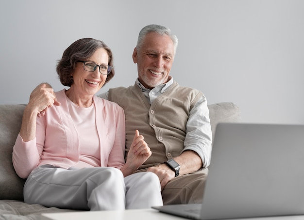 Pareja senior de tiro medio con dispositivo