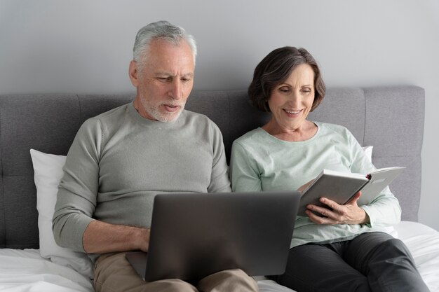 Pareja senior de tiro medio con dispositivos