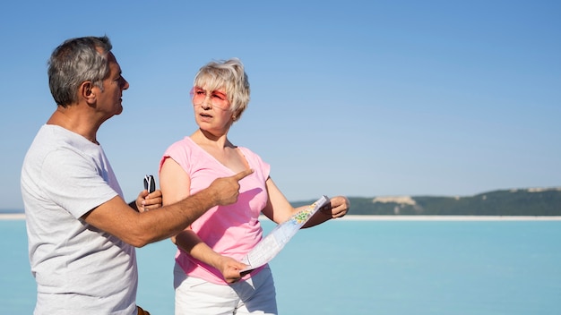 Pareja senior de tiro medio con mapa