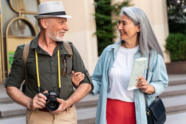 Pareja senior de tiro medio con mapa