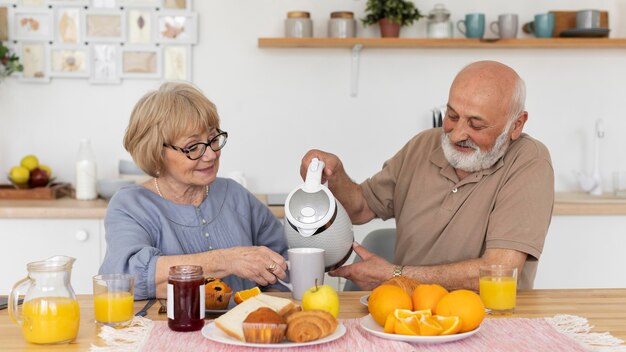 Pareja senior de tiro medio en la mesa