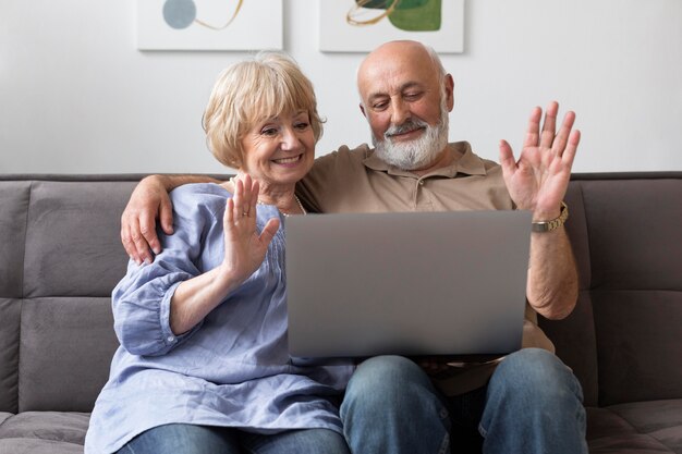 Pareja senior de tiro medio con portátil