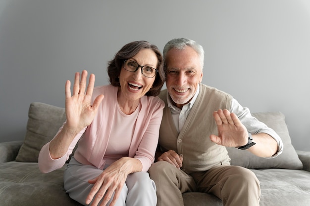 Pareja senior de tiro medio saludando