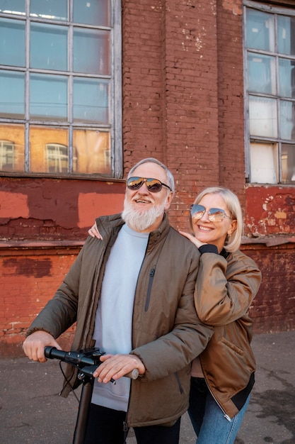 Foto gratuita pareja senior de tiro medio en scooter eléctrico