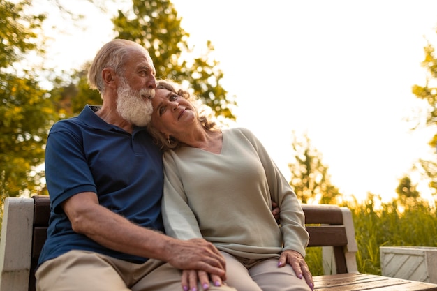 Foto gratuita pareja senior de tiro medio sentado en un banco