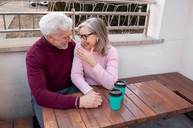 Pareja senior de tiro medio sentados juntos