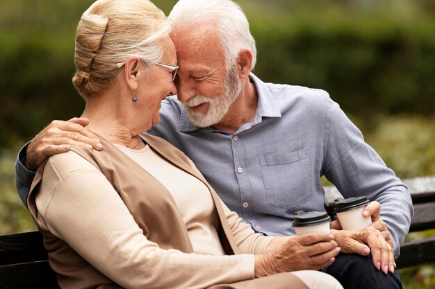 Pareja senior de tiro medio con tazas