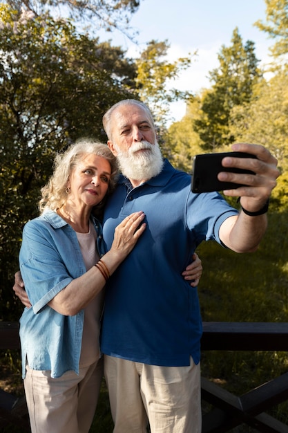 Foto gratuita pareja senior de tiro medio tomando selfie