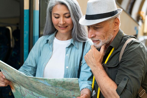 Pareja senior de tiro medio viajando con mapa