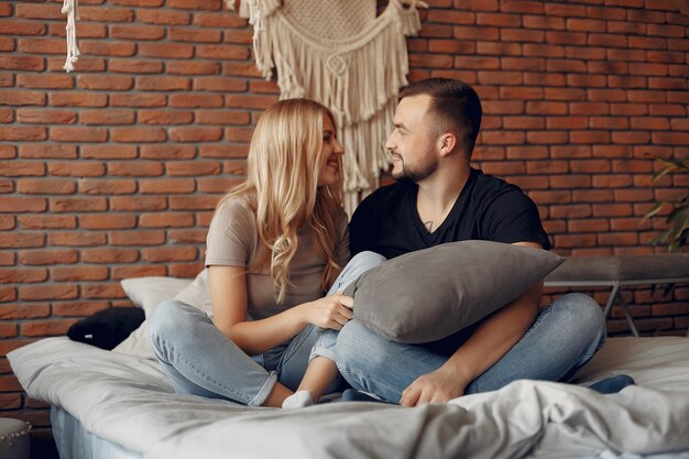 Pareja sentada en una cama en una habitación