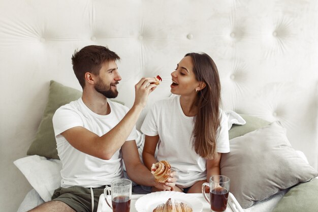 Pareja sentada en una cama en una habitación