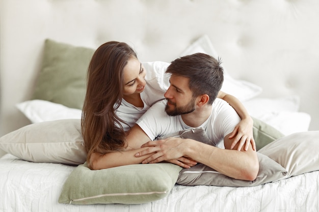 Pareja sentada en una cama en una habitación