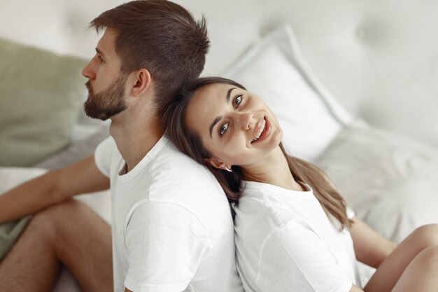 Pareja sentada en una cama en una habitación