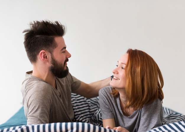 Foto gratuita pareja sentada en la cama y mirándose