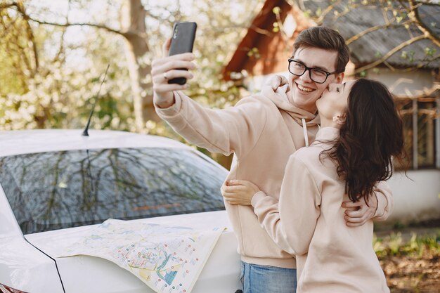 Pareja sentada en un capó del coche en un parque