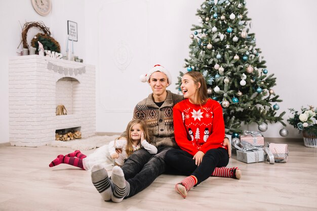 Pareja sentada celebrando navidad en casa