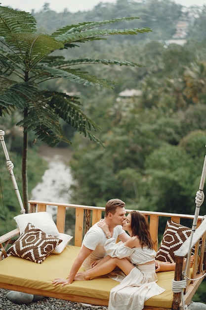 Foto gratuita pareja sentada en un columpio grande en un bali