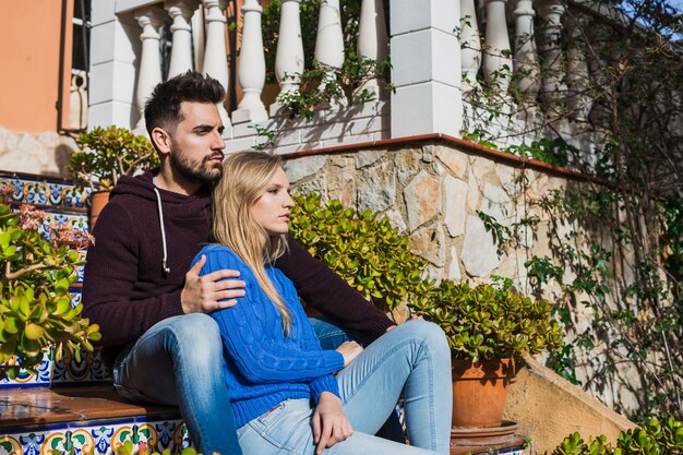 Pareja sentada en las escaleras al aire libre linda