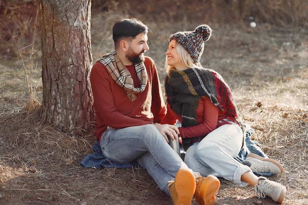 Pareja sentada junto a un árbol en un bosque de primavera