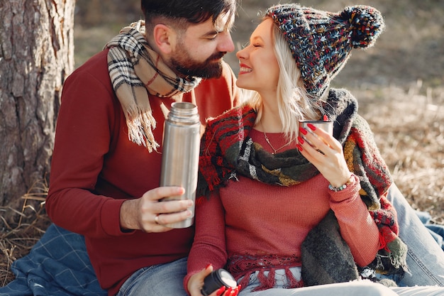 Pareja sentada junto a un árbol en un bosque de primavera