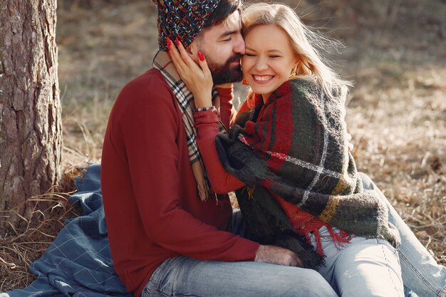 Pareja sentada junto a un árbol en un bosque de primavera