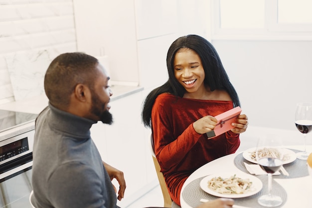 Pareja sentada a la mesa, comer, hablar y reír en el día de San Valentín