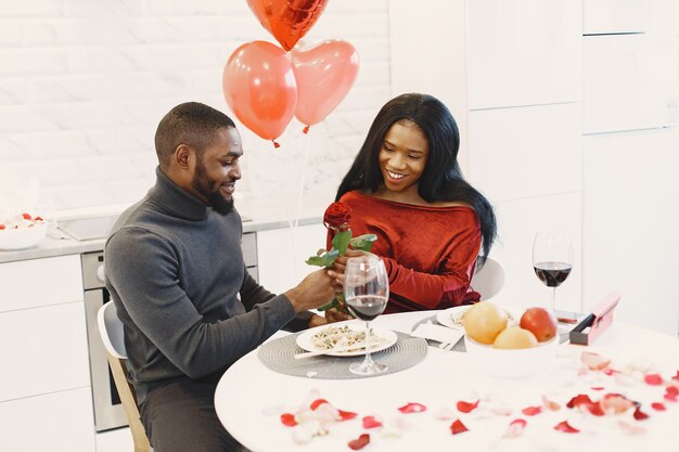 Pareja sentada a la mesa, comer, hablar y reír en el día de San Valentín