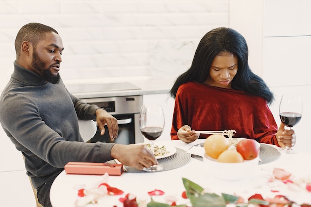 Pareja sentada a la mesa, comer, hablar y reír en el día de San Valentín