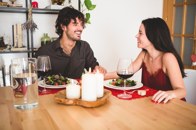 Pareja sentada en una mesa para comer sonriendo