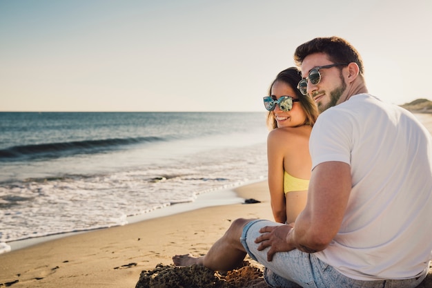 Pareja sentada por la orilla