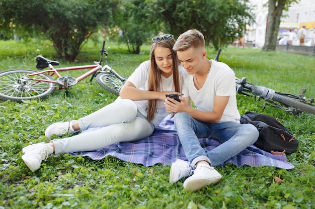 Pareja sentada en un parque con bicicleta