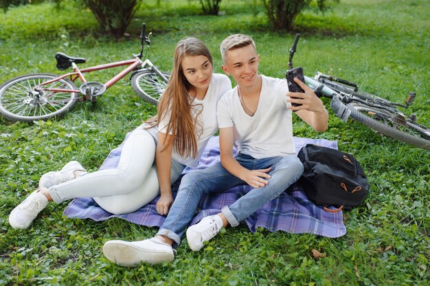 Pareja sentada en un parque con bicicleta