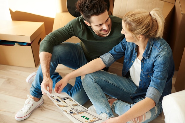 Pareja sentada en el suelo con plano