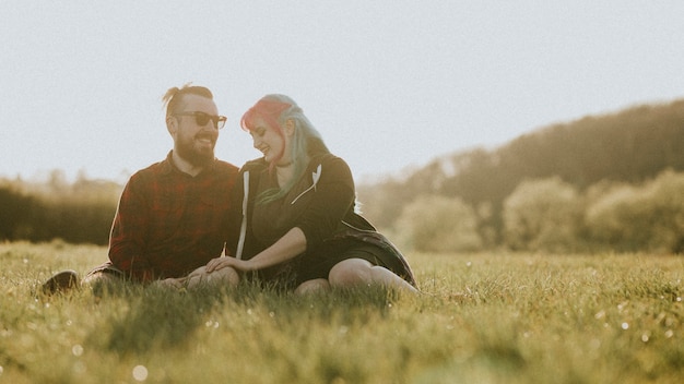 Pareja sentados juntos en el campo