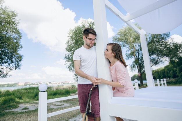 Pareja separada por una columna con una guitarra