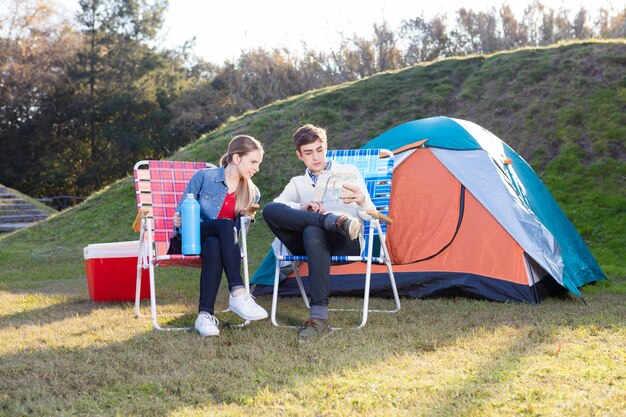 Pareja seria con un mapa en el campamento