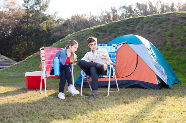 Pareja seria con un mapa en el campamento