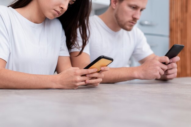 Foto gratuita pareja siendo adicta al primer plano de sus teléfonos