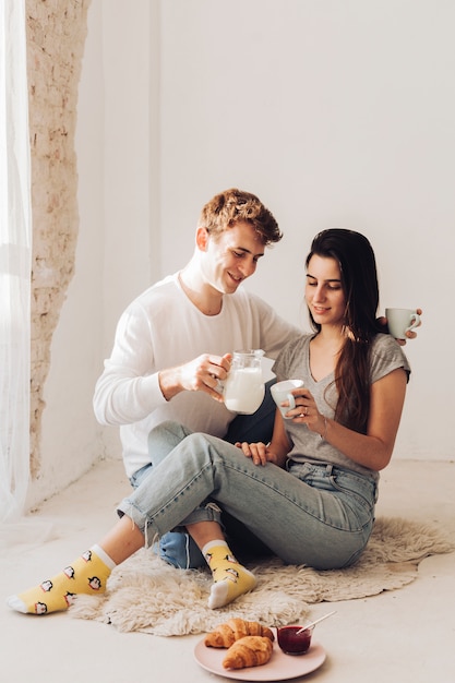 Pareja sirviendo leche a su novia