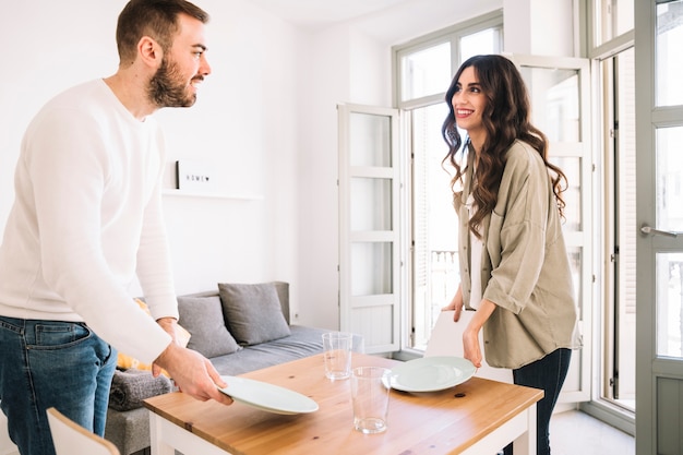 Foto gratuita pareja sirviendo mesa en casa