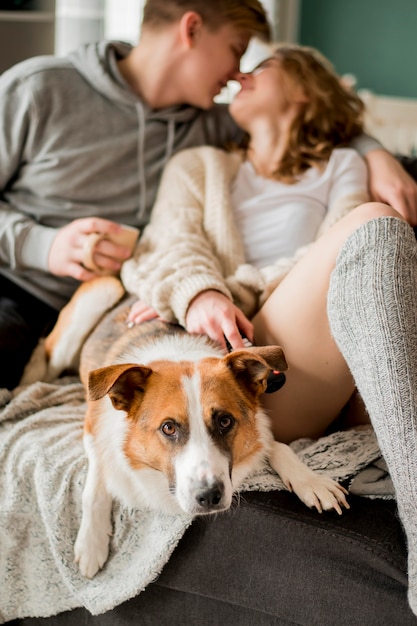 Pareja en el sofá con besos de perro