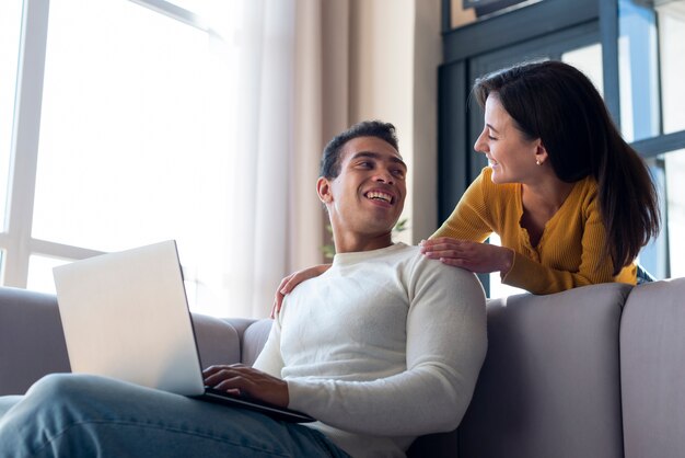 Pareja en el sofá sonriendo el uno al otro