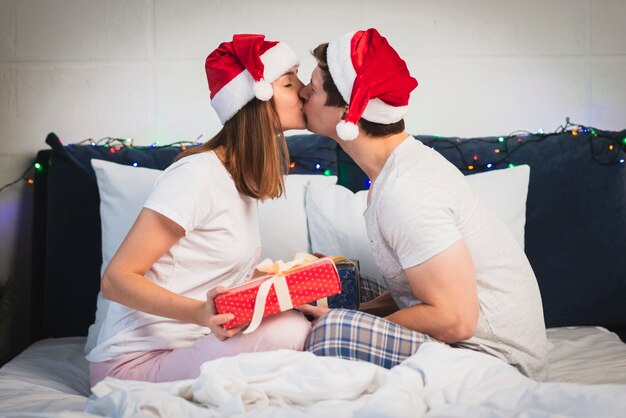 Pareja con sombreros de santa besos