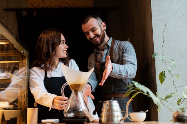 Pareja sonriendo y apuntando al filtro de café