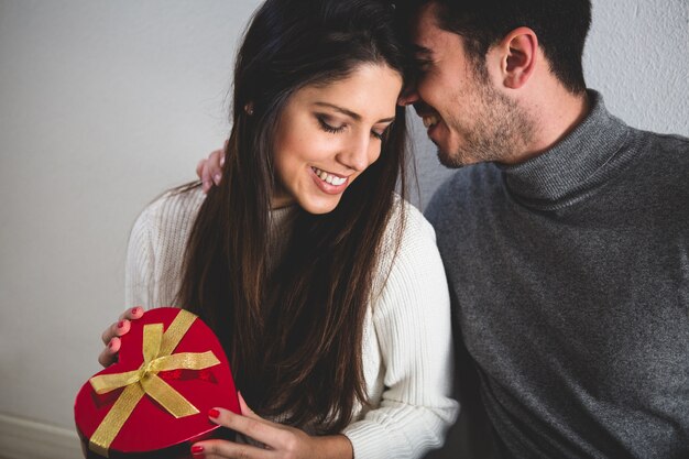 Foto gratuita pareja sonriendo y ella con un regalo en las manos