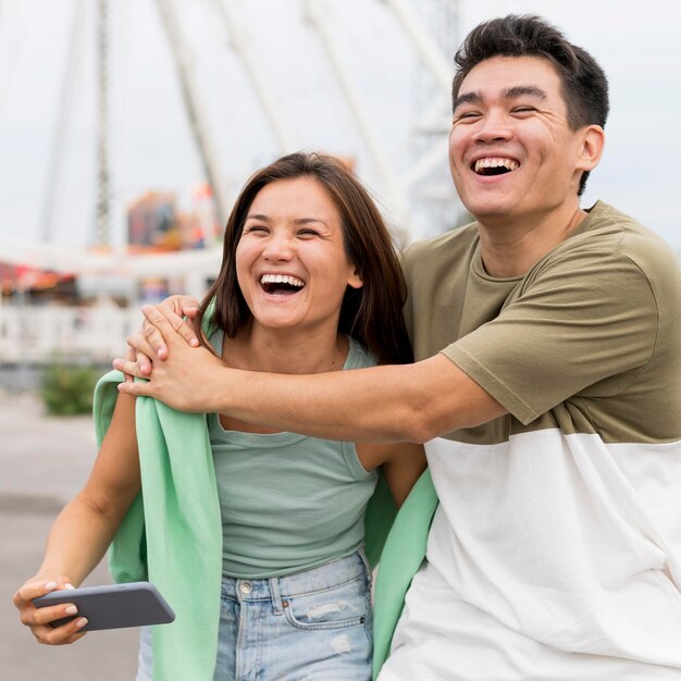 Pareja sonriente abrazada al aire libre