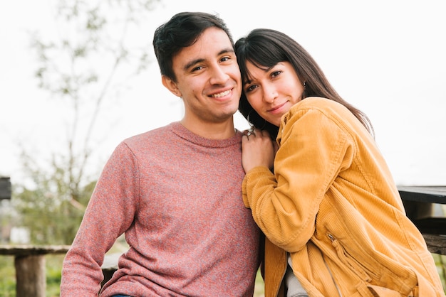 Foto gratuita pareja sonriente abrazando y mirando a cámara