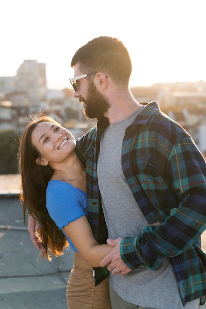 Pareja sonriente abrazo al aire libre en la ciudad