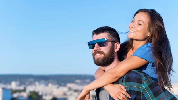 Foto gratuita pareja sonriente al aire libre en la ciudad con espacio de copia