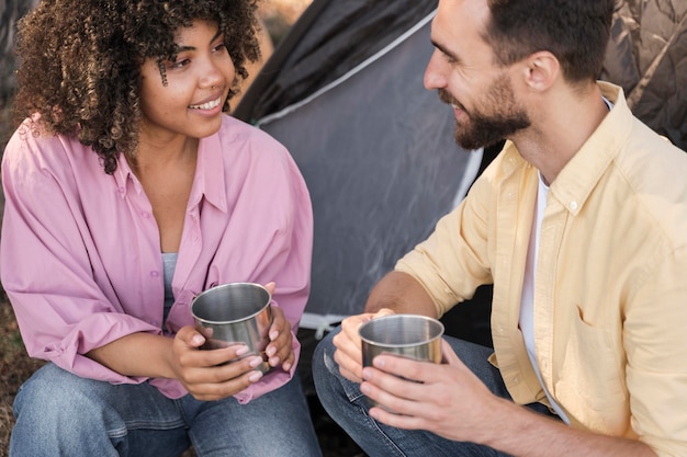 Pareja sonriente al aire libre tomando una copa